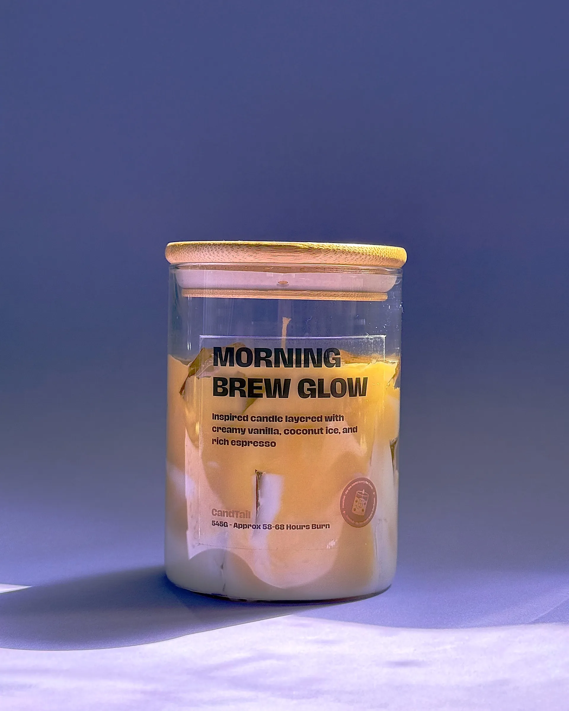 Morning Brew Glow candle photographed against a purple backdrop