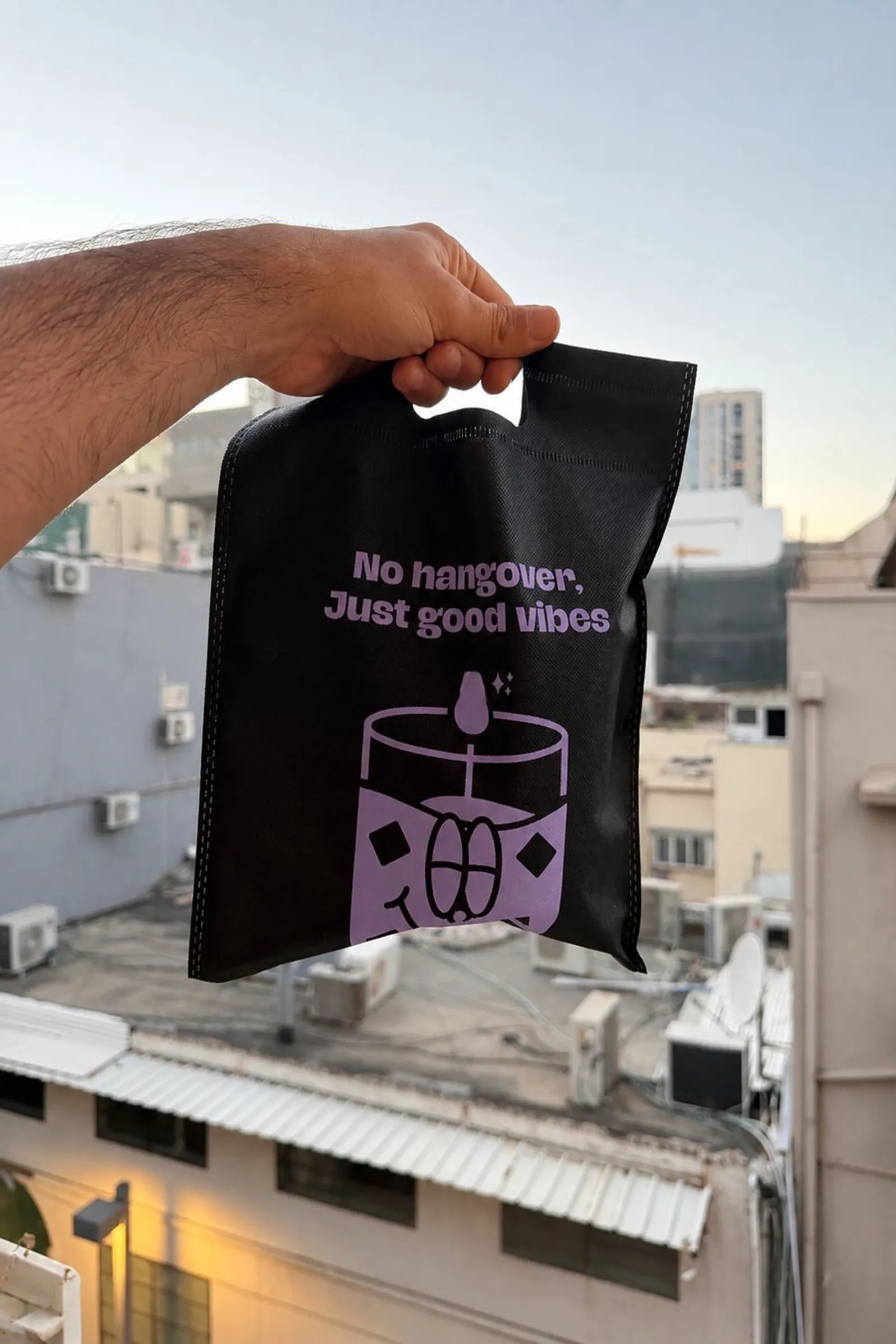 A Candtail order in a branded black bag, handed over on a city street