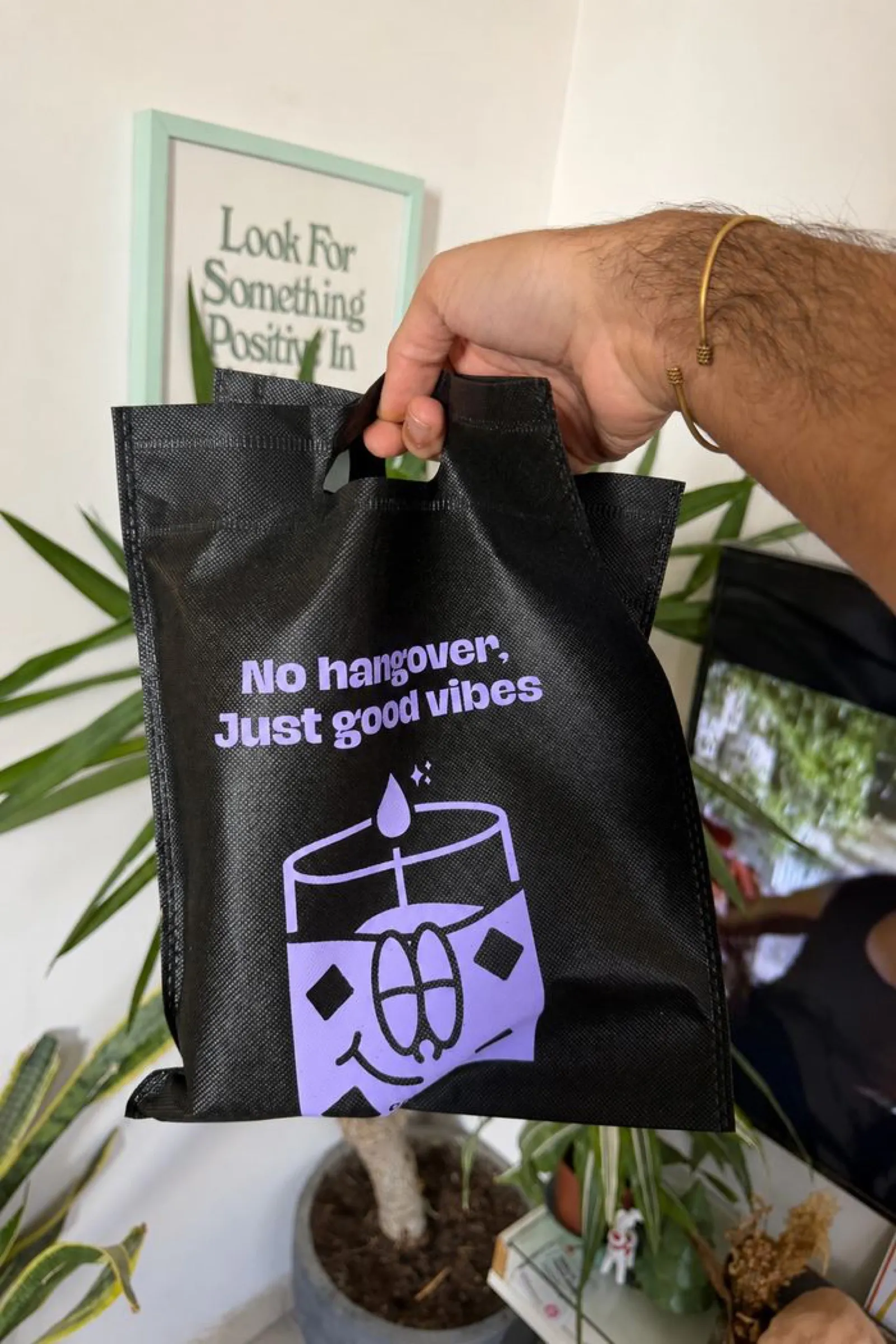 A Candtail order bag beside plants