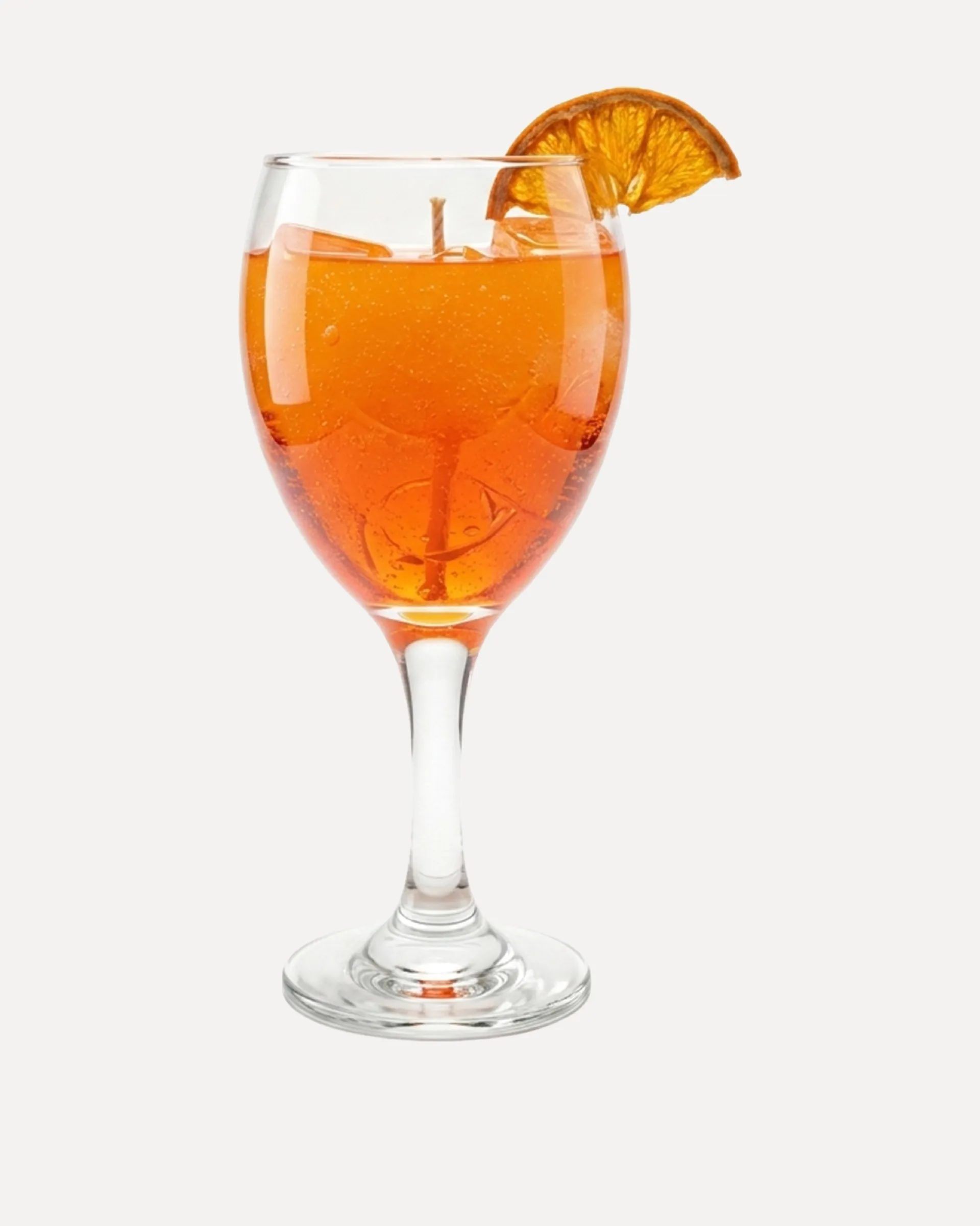 Aperol Spritz candle in a stemmed glass with a dried orange slice